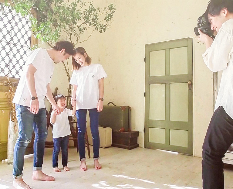 スタジオで撮影している家族とカメラマンの写真