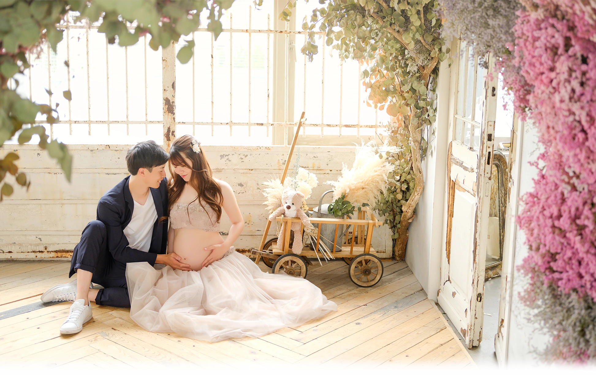 マタニティフォトのドライフラワーの中で夫婦が寄り添った全身写真