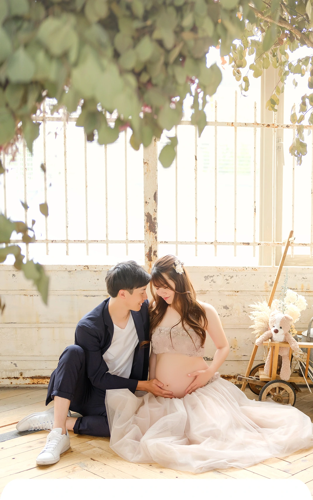 マタニティフォトのドライフラワーの中で夫婦が寄り添った全身写真